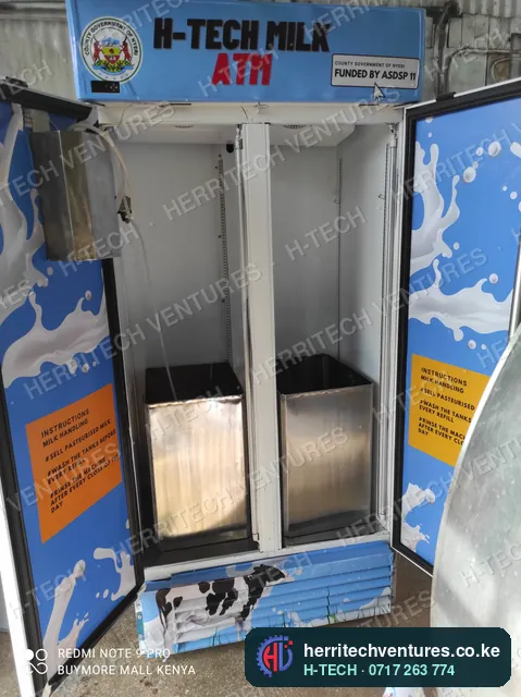 Inside a double-door milk ATM: two stainless milk tanks and dispensing bays, April 2022